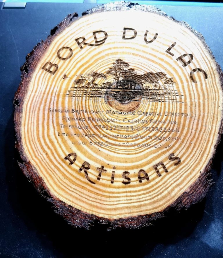 bord-du-lac-logo-branding-on-pine-live-edge-stand Bord Du Lac Artisan logo engraved on a pine waney edge stand with feet.